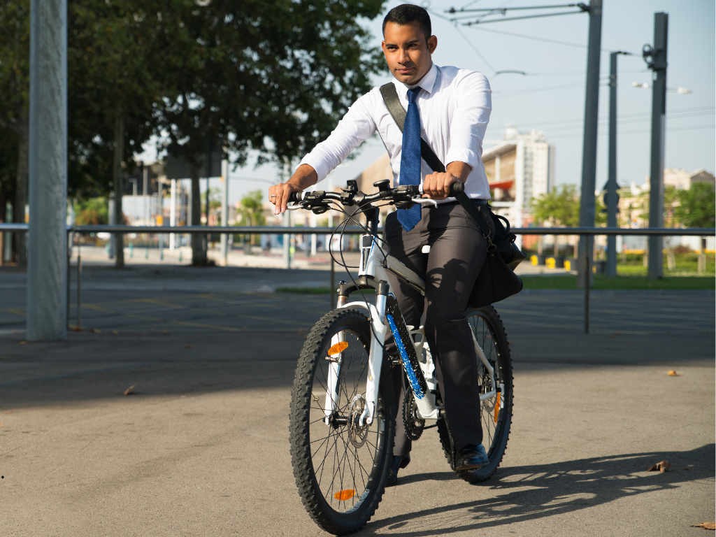 En la imagen se ve una persona yendo al trabajo en una bicicleta