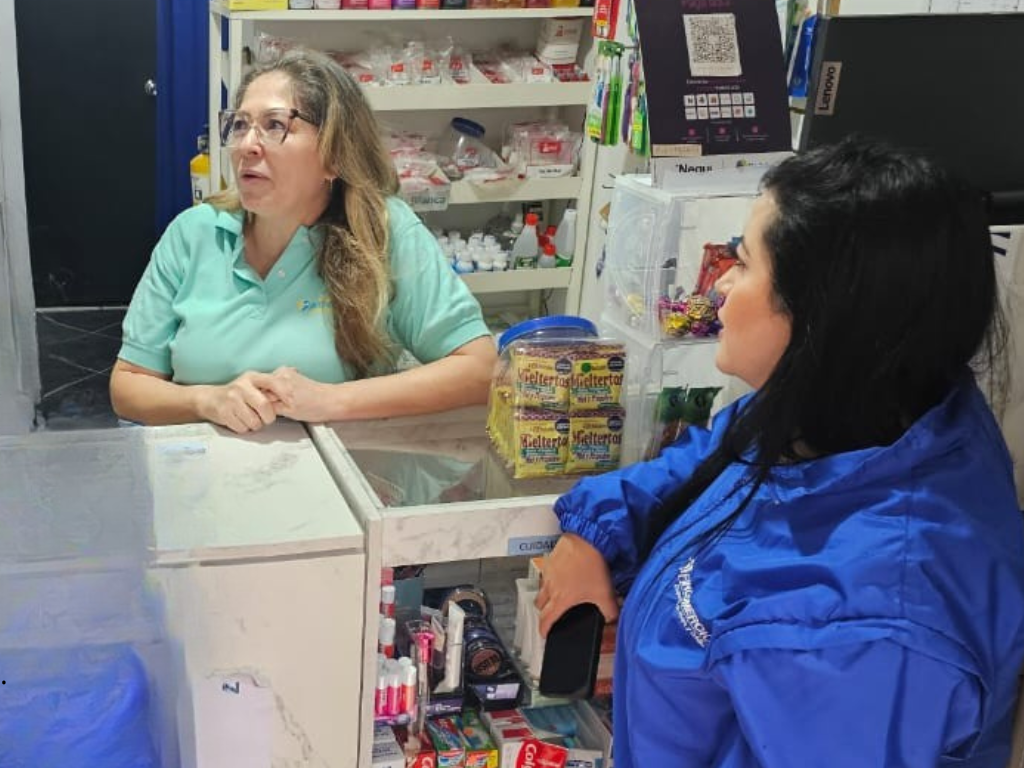 En la foto aparece una tendrera que está siendo atendida por una impulsadora de Fincomercio